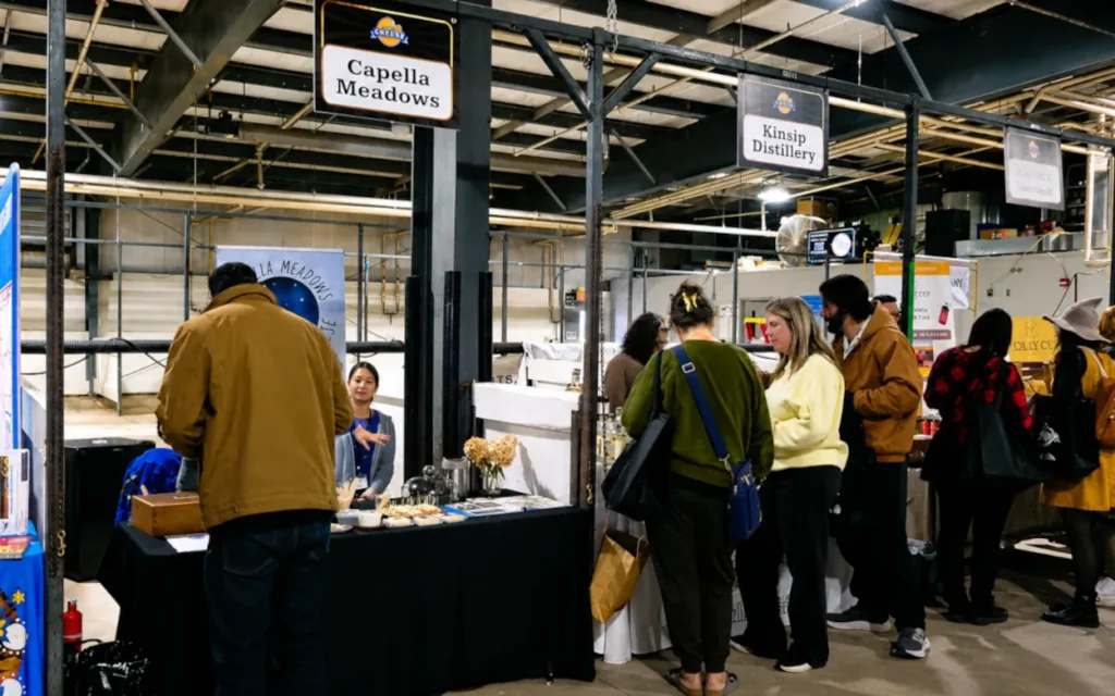 Early attendees speaking with vendors at the Ontario Cheese Festival , 2025.